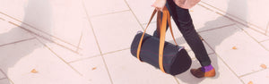 Ein schwarzes Barrelbag wird von einer jungen Frau ausgeführt. 